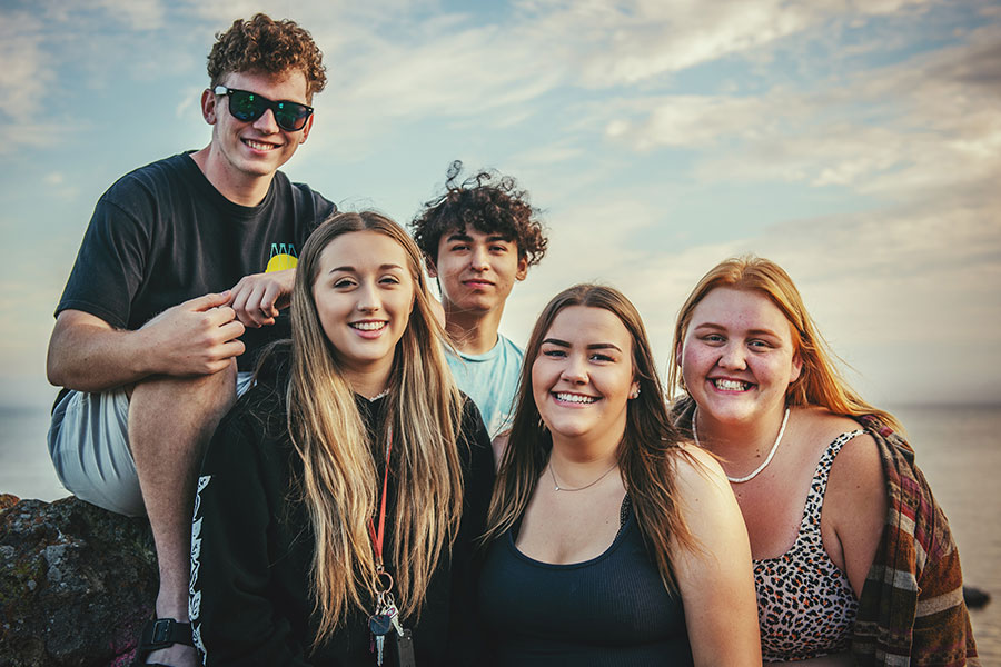 Group of teenagers smiling at the beach